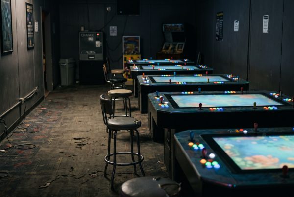 Row of glowing fish game cabinets in an empty arcade room for fish table games near me (includes the focus keyphrase)